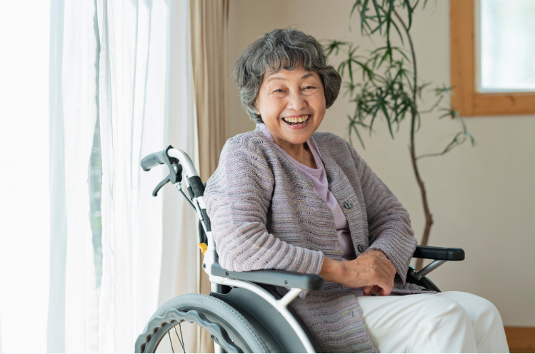 A smiling senior woman in a wheelchair using a tablet to access smart home technology